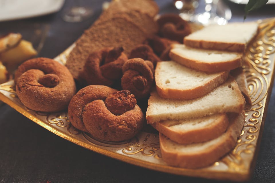 A variety of breads and pastries elegantly arranged on a decorative plate.